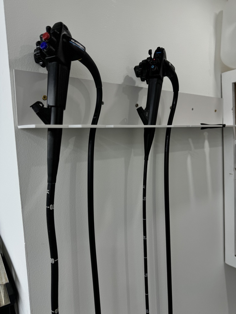 EV charging cables hung on white wall rack