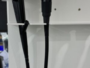 Industrial pilot valve and hydraulic hoses mounted on wall.