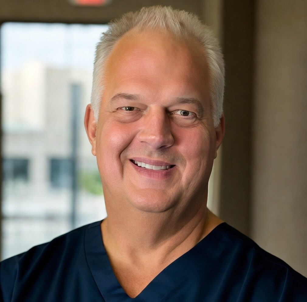 Smiling male nurse in blue scrubs