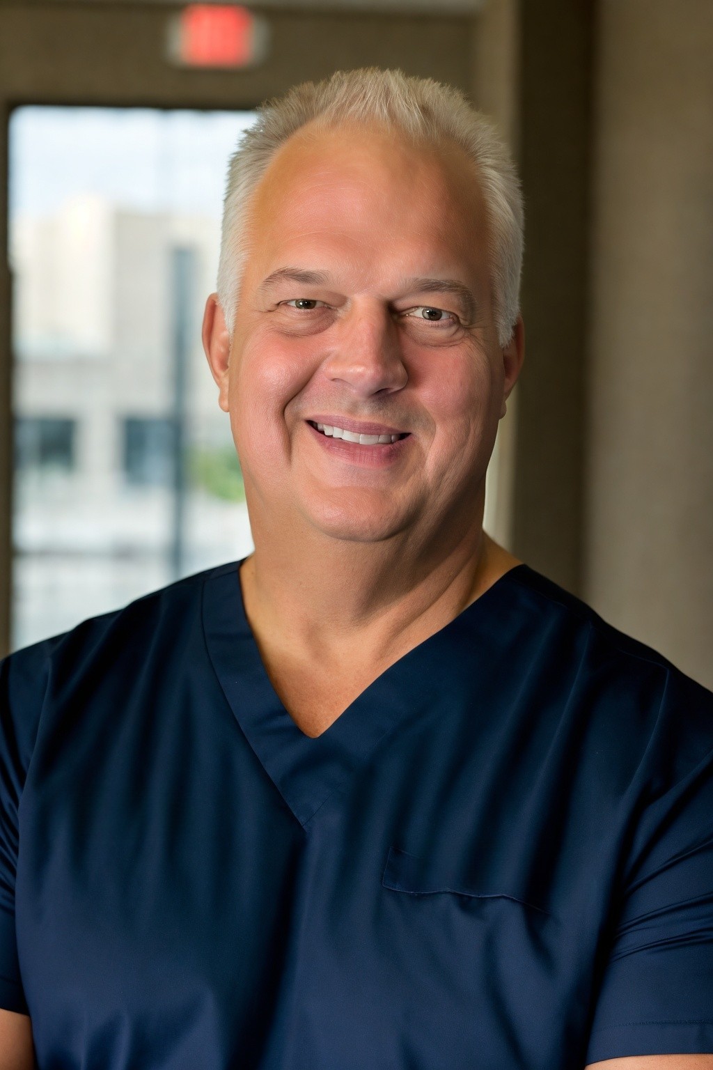 Smiling male nurse in blue scrubs