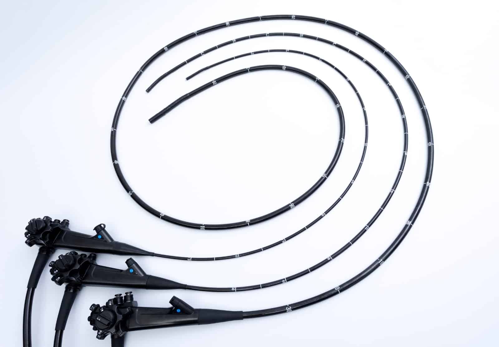 Coiled black industrial hoses with connectors on white