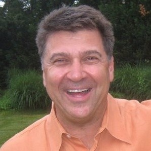 Smiling man in orange shirt outdoors